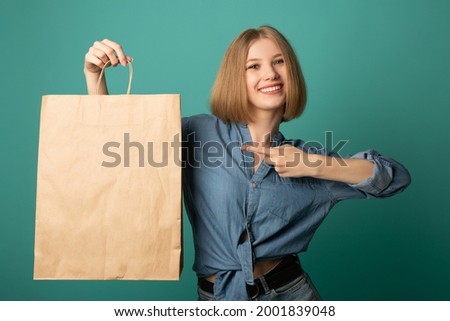 beautiful young woman with paper bag in hand 