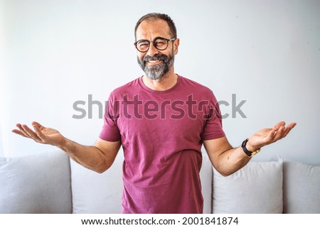 Portrait of a mature businessman wearing glasses on grey background. Happy man looking at camera isolated over grey wall with copy space. Close up face of happy successful business man. Royalty-Free Stock Photo #2001841874