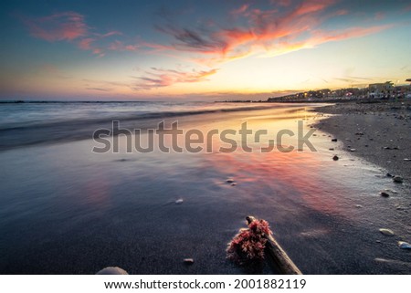 Sunset of the Roman sea. Red clouds over the beach in Ostia, Rome, Italy Royalty-Free Stock Photo #2001882119