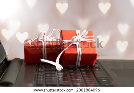 Pile of red gift boxes with white ribbon  and  on laptop keyboard.  present and celebration concept.