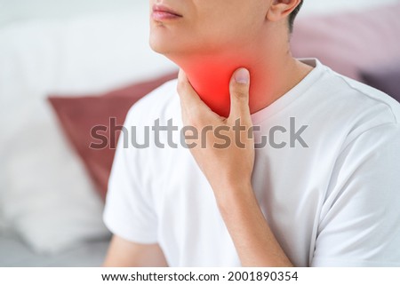 Sore throat, men with pain in neck in home interior, health problems concept Royalty-Free Stock Photo #2001890354