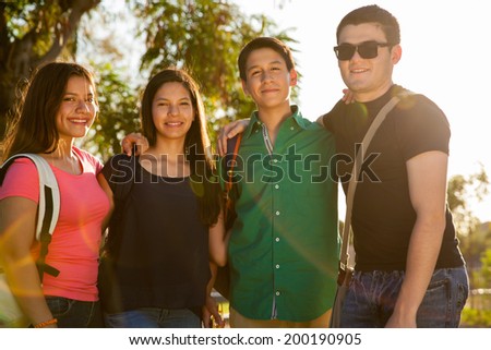 Portrait of a group of cool high school teenagers hanging out at sunset