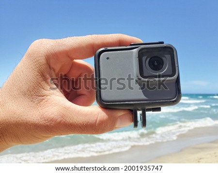 Man hand while holding action water resistent camera before filming sport session,tech devices