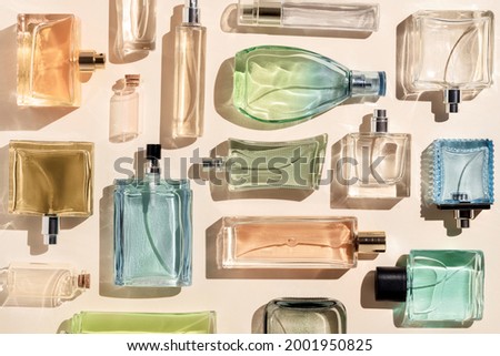 perfume bottles. a lot of transparent multicolored glass bottles of cosmetics, on a beige background. art composition flat lay still life Royalty-Free Stock Photo #2001950825