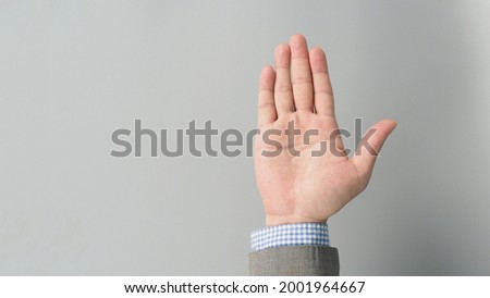 Hand suit and empty palm in grey suit color on grey background. Businessman topic.close up photo and studio shooting.


