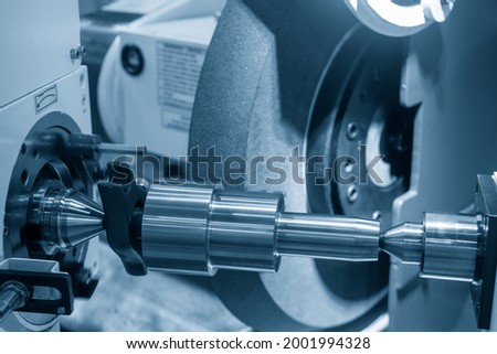 The cylindrical grinding machine control by CNC program. The hi-technology precision part manufacturing process by surface grinding machine.  Royalty-Free Stock Photo #2001994328