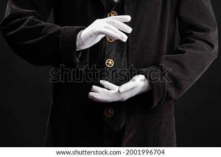 Hand gestures. spell with your hands. Showman or magician illusionist in white gloves on a black background.