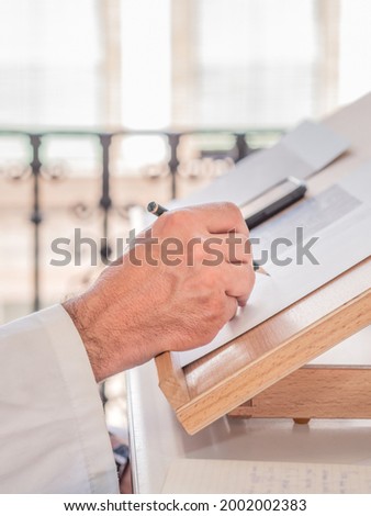 Artist's hand sketching at his worktable