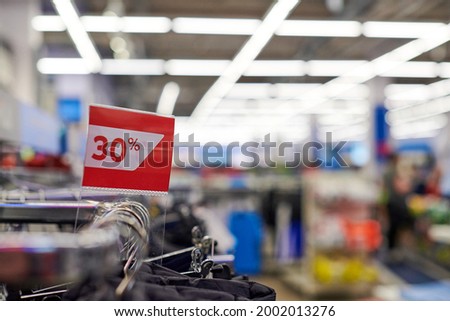 Seasonal sale 30% off, holiday discounts in shopping mall, Black Friday. New Year's sale time at european shopping center. Christmas promotions in clothing store. Sportswear and clothes.
