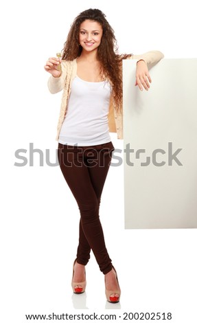 Portrait of a young woman holding blank card and key- over white background.