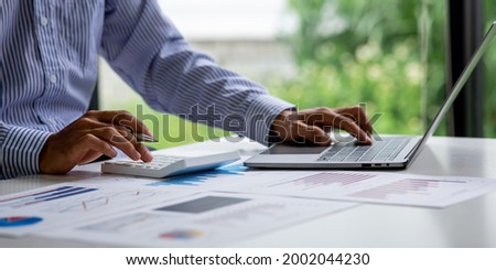 Business man hand hold documents with financial statistic stock photo,discussion and analysis data the charts and graphs.Market research reports Accounting Finance concept