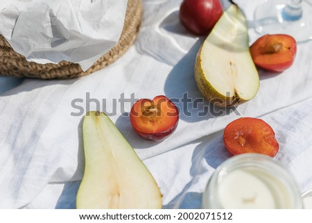 a cozy picnic in nature, on the pier. Close-up of fresh fruit, champagne glasses, a white sheet.