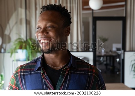 Head shot portrait of dreamy smiling African American businessman looking to aside, excited successful employee executive manager visualizing new job opportunities, planning, business vision concept