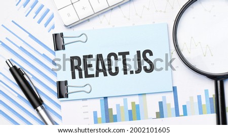 Top view of text react js with calculator, magnifying glass and pen on financial charts . Business, calculation, strategy, searching and tax concept. Top view. Royalty-Free Stock Photo #2002101605
