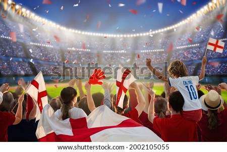 England football supporter on stadium. English fans on soccer pitch watching team play. Group of British supporters with flag and national jersey cheering for UK. Championship game. Go Britain! Royalty-Free Stock Photo #2002105055
