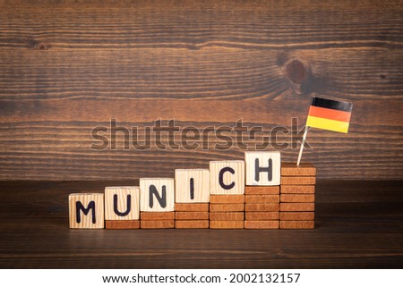 MUNICH city in germany. Wooden alphabet letters and German flag on a wooden background.