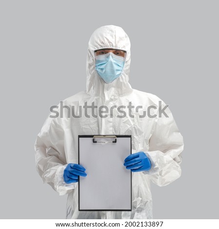 A man in a protective antibacterial suit. The concept of anti-epidemic measures. A warning sign. AntiCOVID. Vaccine against coronavirus