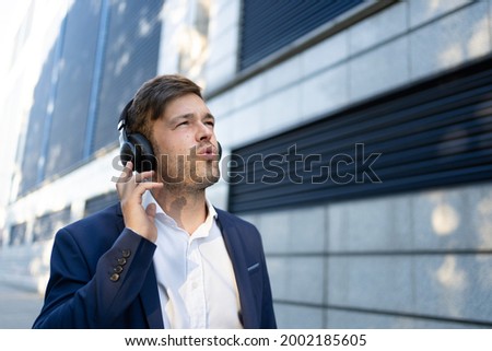 A young man in a suit wearing headphones