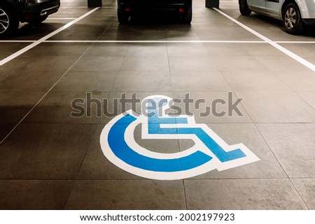 Sign painted on the ground in a large car park reserved for people with disabilities
