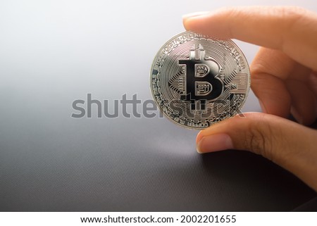 Hand Staff woman holding Bitcoin crypto currency on black background. technology planing earn money investment and saving money future for 2022 new year. finance and business concept.
