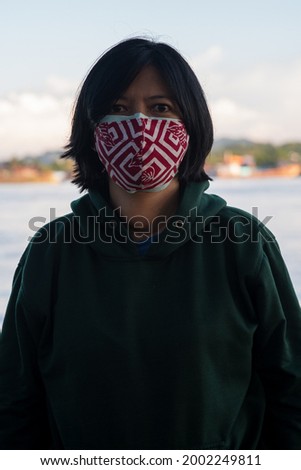 Double masks prevent the new variant of covid-19. Portrait of an Indonesian woman wearing a double mask.