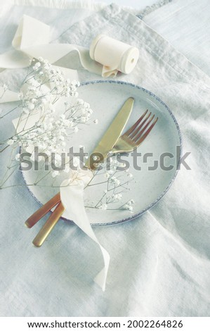 Empty modern minimal table place setting neutral color and white flowers  top view.  Space for text. wedding invitation. Scandinavian style.