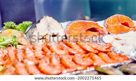 Sea market, fresh trout, cod and tuna meat, boiled red king prawns.