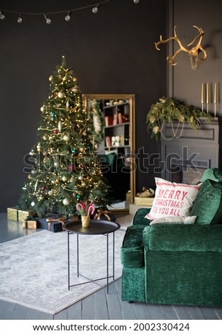 Dark Christmas interior with Christmas tree, fireplace and emerald sofa