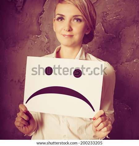 woman holding frames with sad faces. concept photo over dark background. Photo with instagram style filters