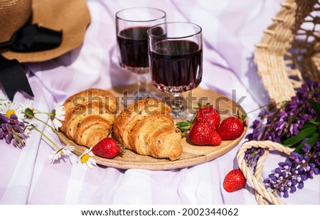 Romantic picnic scene on summer day. Outdoor picnic with wine and a  fruit  in the open air on the background of green grass.