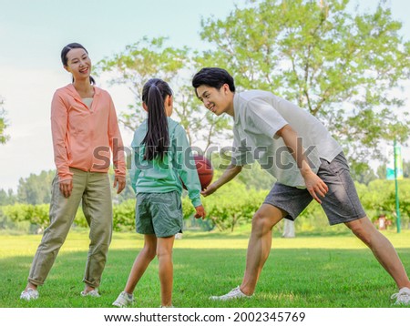 Happy family of three playing basketball in the park high quality photo