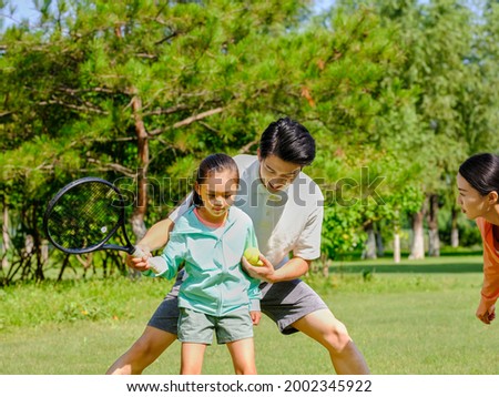 Happy father and daughter are playing tennis in the park high quality photo