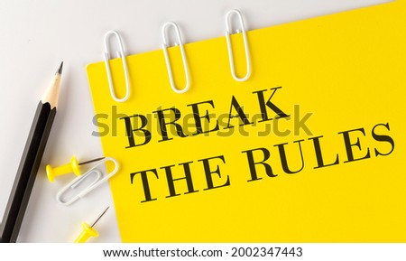 BREAK THE RULES word on the yellow paper with office tools on the white background
