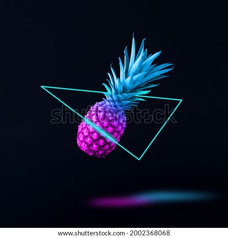 Flying retro wave pineapple in neon triangle with shadow. Minimal abstract synthwave or vaporwave. Futuristic creative idea. Royalty-Free Stock Photo #2002368068
