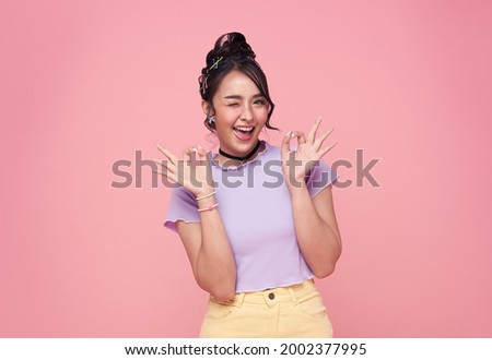Happy Asian young woman gesture or showing hand ok isolated on pink background.