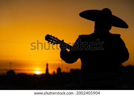 Mexican, Latin American, Spanish. Musician at sunset. Royalty-Free Stock Photo #2002405904