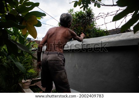 An old man is still passionate about working as a wall cleaner during the covid-19 pandemic.