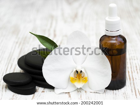 Spa stones, orchid flower heads on a wooden  background