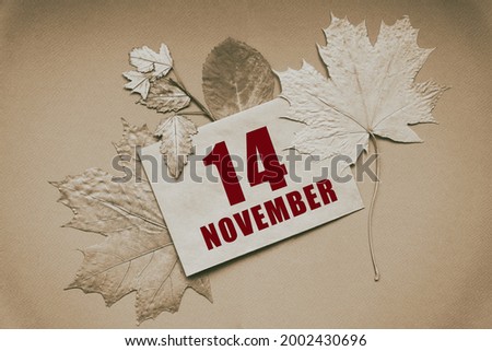 november 14. 14th day of month, calendar date.Envelope with the date and month, surrounded by autumn leaves on brown background. Autumn month, day of  year concept.