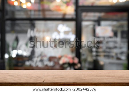 Wooden table top with blur background of cafe and bistro.