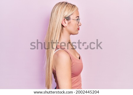 Young blonde girl wearing casual clothes looking to side, relax profile pose with natural face and confident smile. 