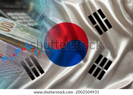 national flag of South Korea on satin, dollar bills, computer, concept of global trading on the stock exchange, falling and rising prices for world currency