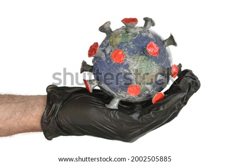 A human hand holds the globe in the form of a virus on a white background