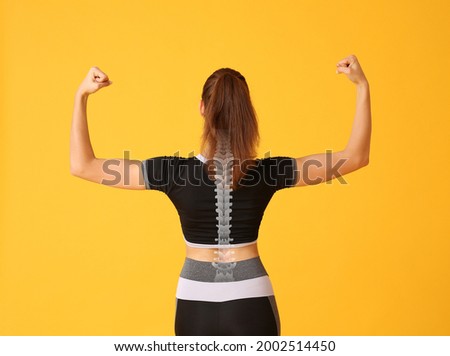 Sporty young woman with good posture on color background Royalty-Free Stock Photo #2002514450