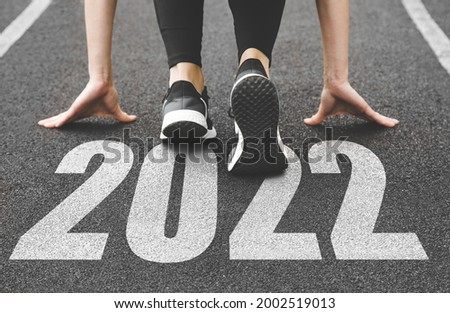 close-up of female feet in sneakers at the start. Beginning and start of the new year 2022, goals and plans for the next year Royalty-Free Stock Photo #2002519013