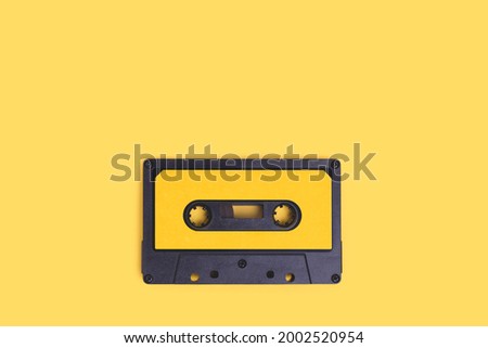 Cassette tape on a yellow background with copy space.