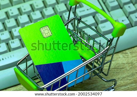 shopping cart with a credit card on the background of a computer keyboard concept internet business online banking. High quality photo