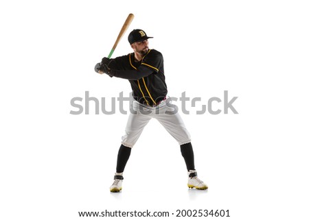 Grand slam. Baseball player, pitcher in a black white sports uniform practicing isolated on a white studio background. Young sportsman in action. Competition, show, movement and team sport concept.