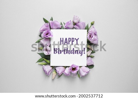 Beautiful flowers and card with text Happy Birthday! on grey background, flat lay