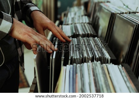 Man choosing vinyl records in store, closeup Royalty-Free Stock Photo #2002537718